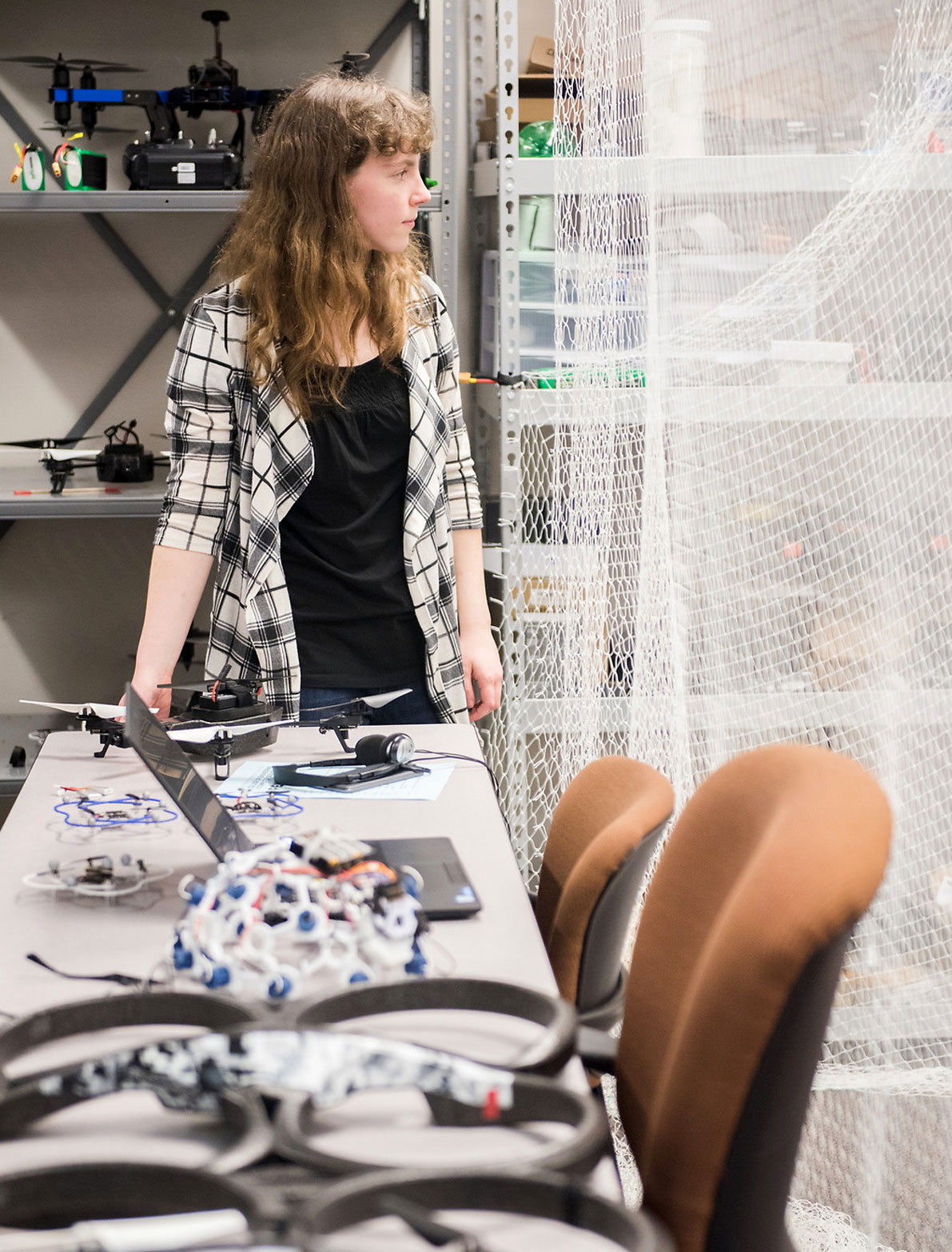 A UT student at a workbench with drone equipment