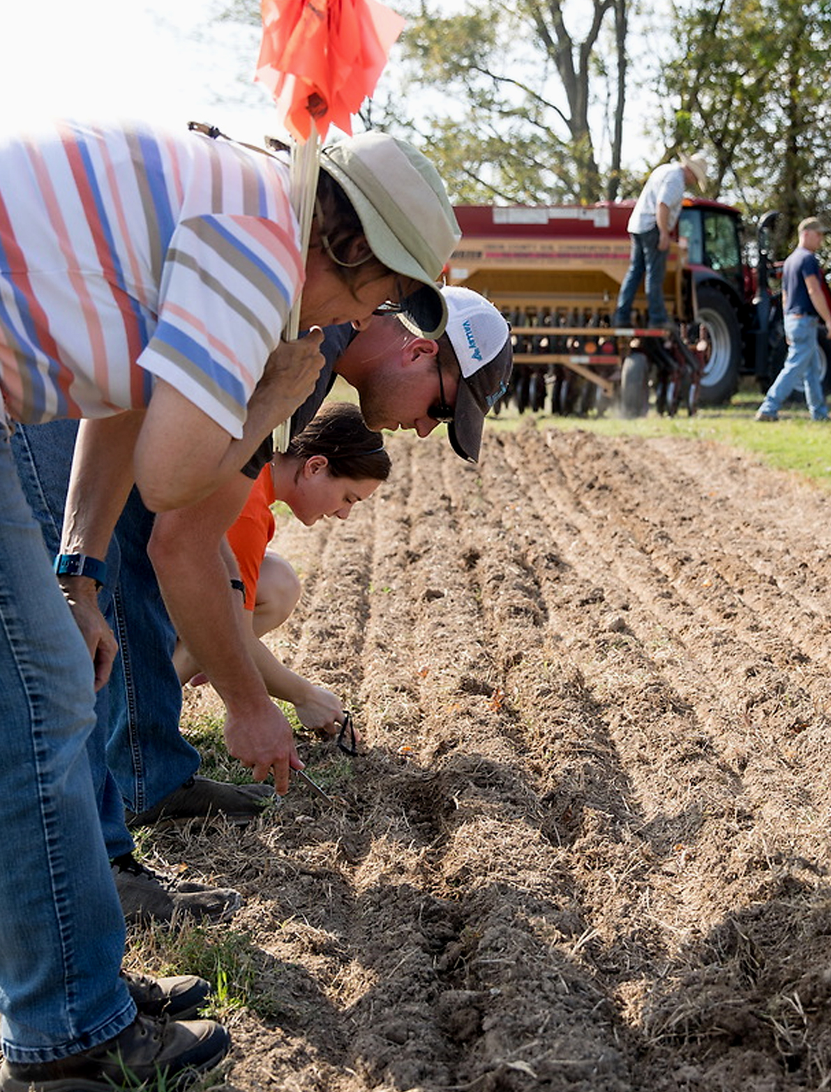 researchers take soil samples on a farm field