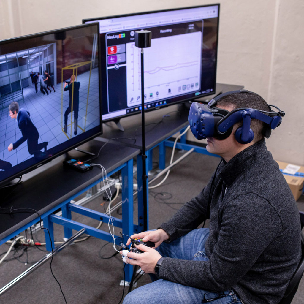 researcher using a game controller and VR helmet