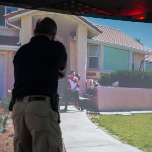 A close up of a police officer drawign a simulated weapon in a V R hostage situation