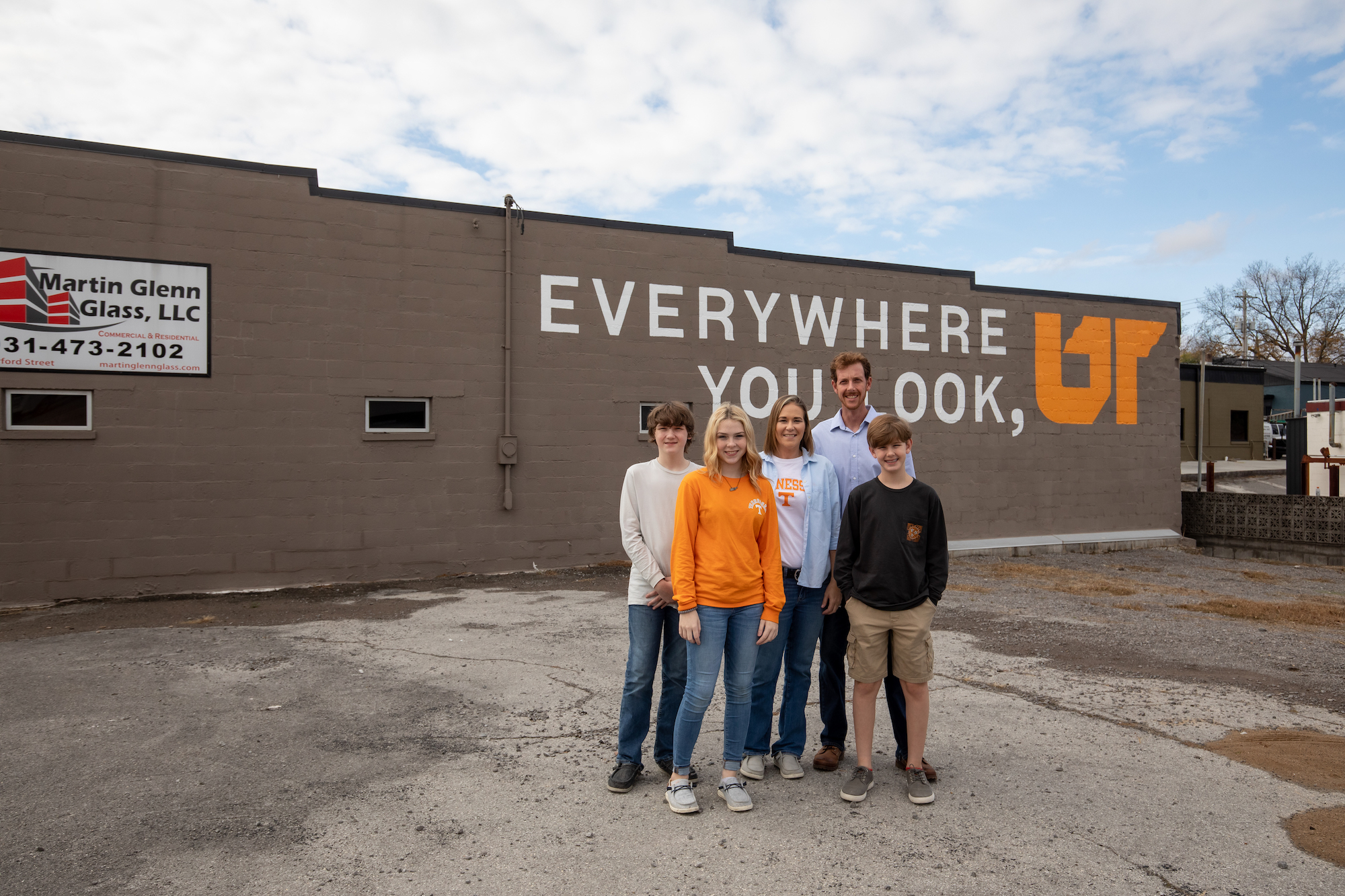 The Randolph family standing in front of the UT mural in McMinnville