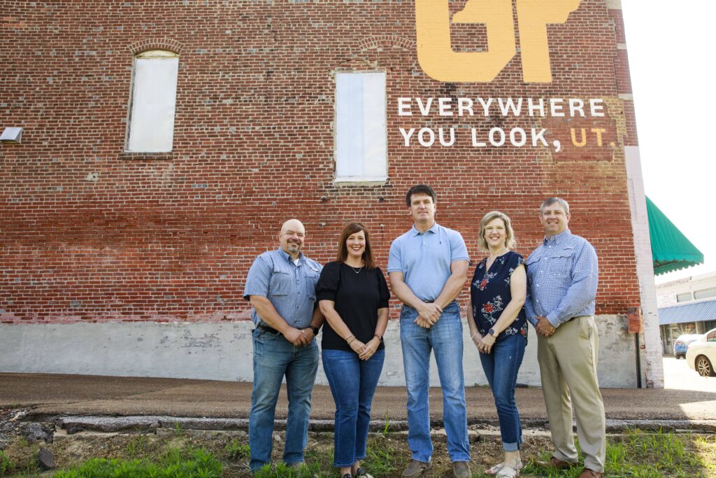 Owners of Kenton Drug Company pose in front of UT mural