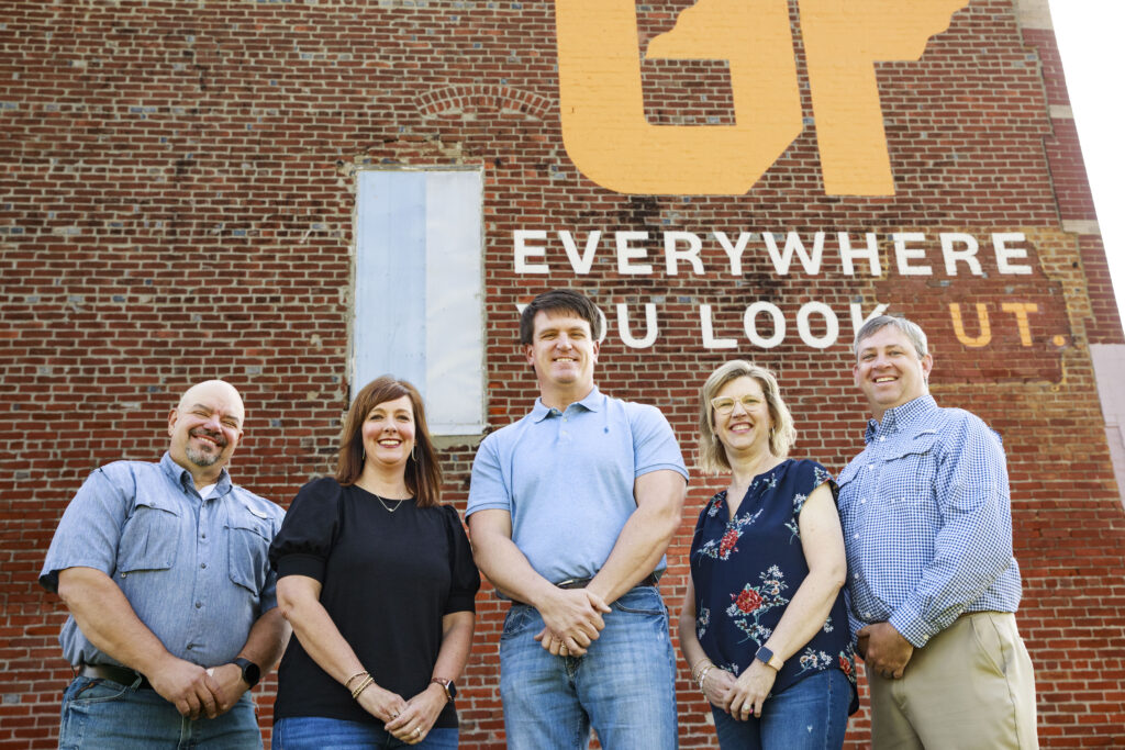 Owners of Kenton Drug Company pose in front of UT mural