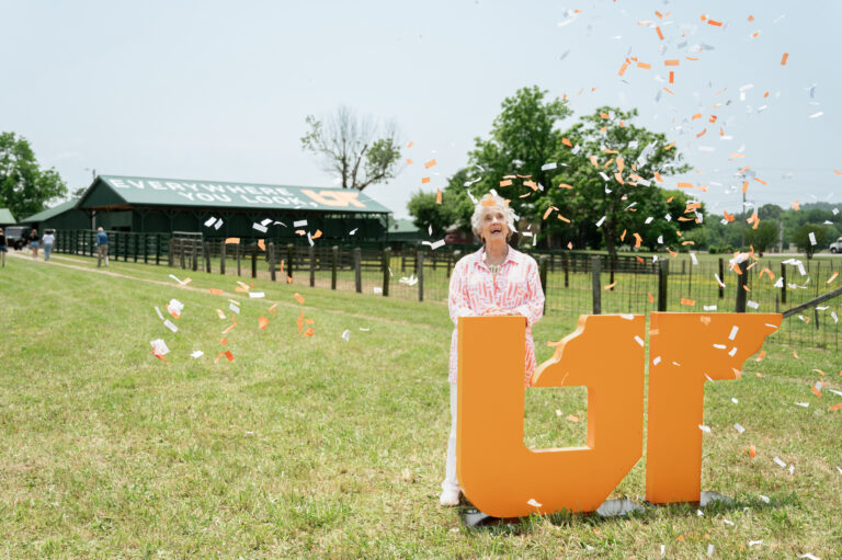 Rena Johnson standing in front of the UT mural at Johnson Farm while confetti falls during the dedication ceremony held May 26, 2023, in Sparta