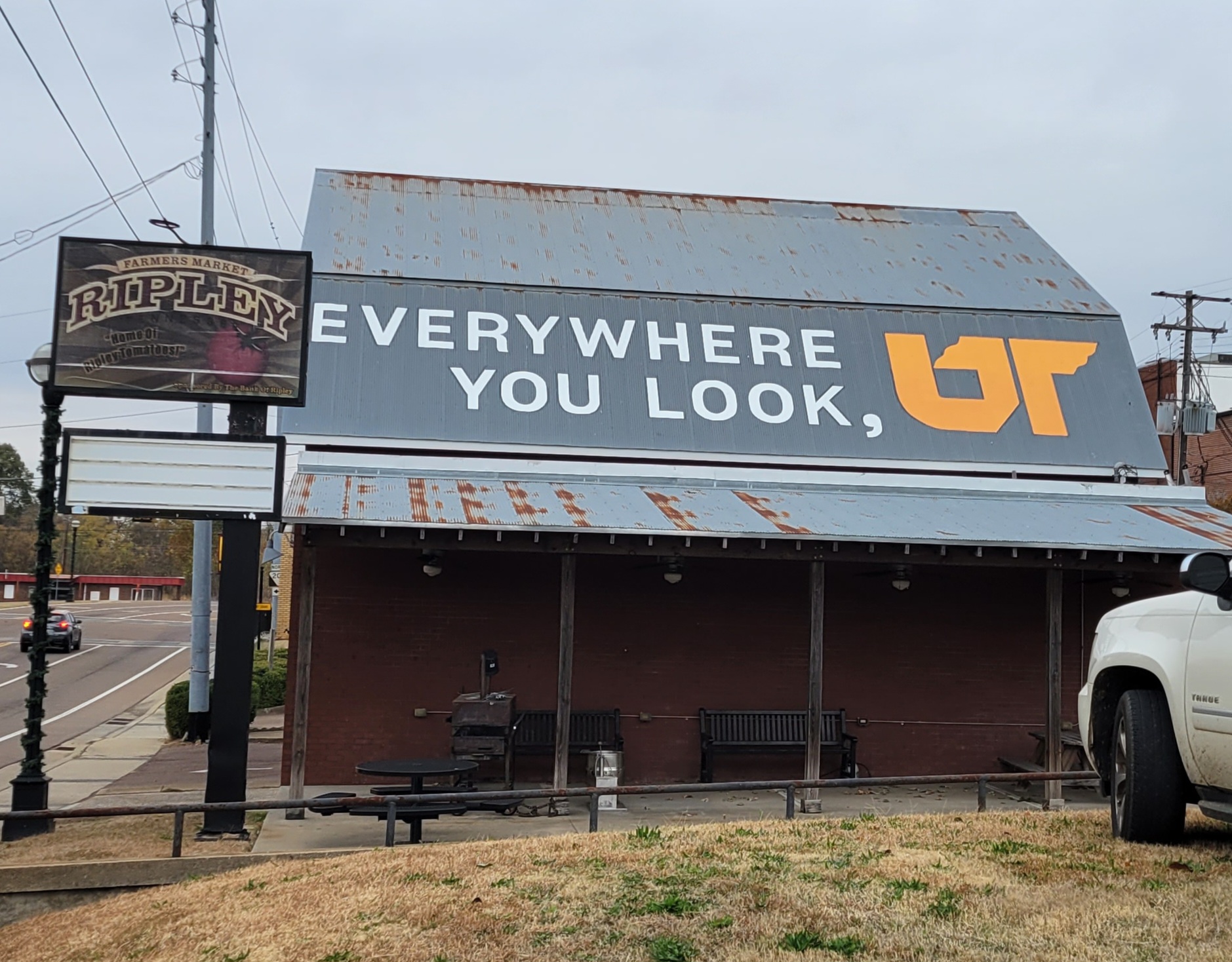 Orange and white "Everywhere You Look, UT" mural painted on gray metal barn roof in downtown Ripley, Tennessee