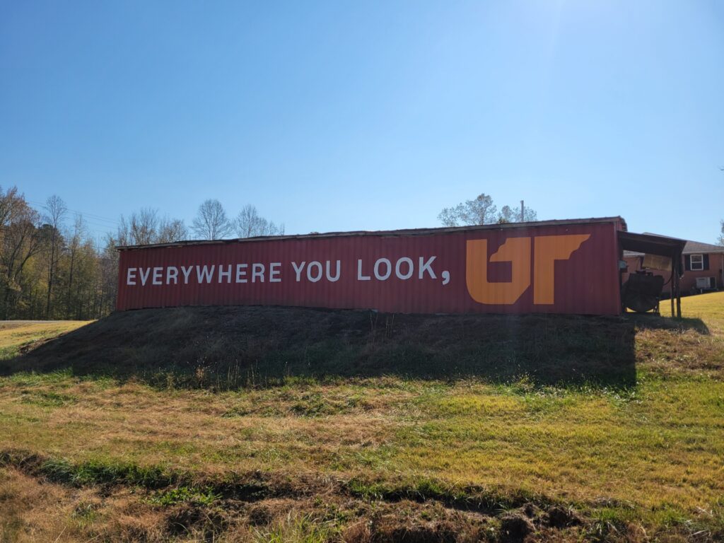 Orange and white Everywhere You Look, UT mural painted on red barn in Lexington, Tennessee