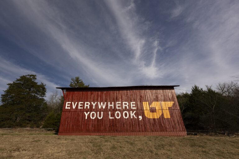 Orange and white "Everywhere You Look, UT" mural on red barn in Riddleton, Tennessee