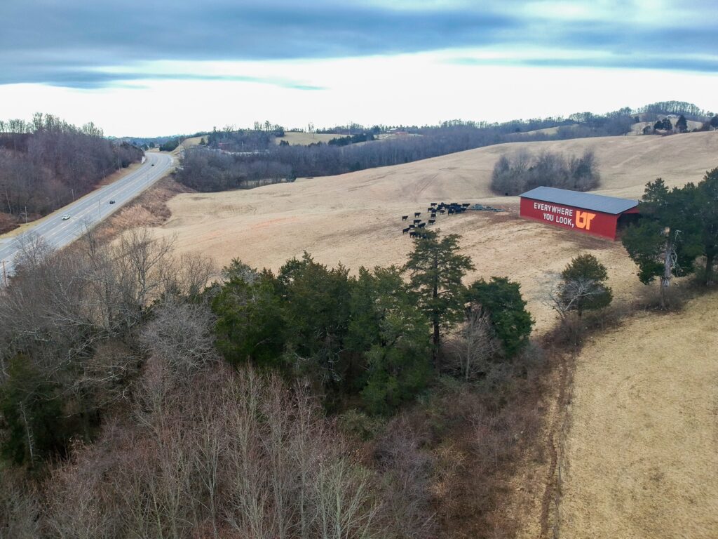 Aerial photo of red barn painted with orange and white Everywhere You Look, UT mural overlooking Highway 25E in Tazewell, Tennessee