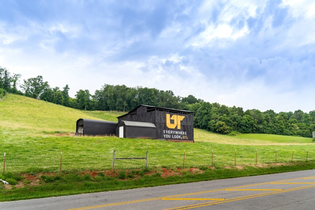 Black wood barn with orange and white Everywhere You Look, UT mural on Gann Farm in Jefferson City, Tennessee